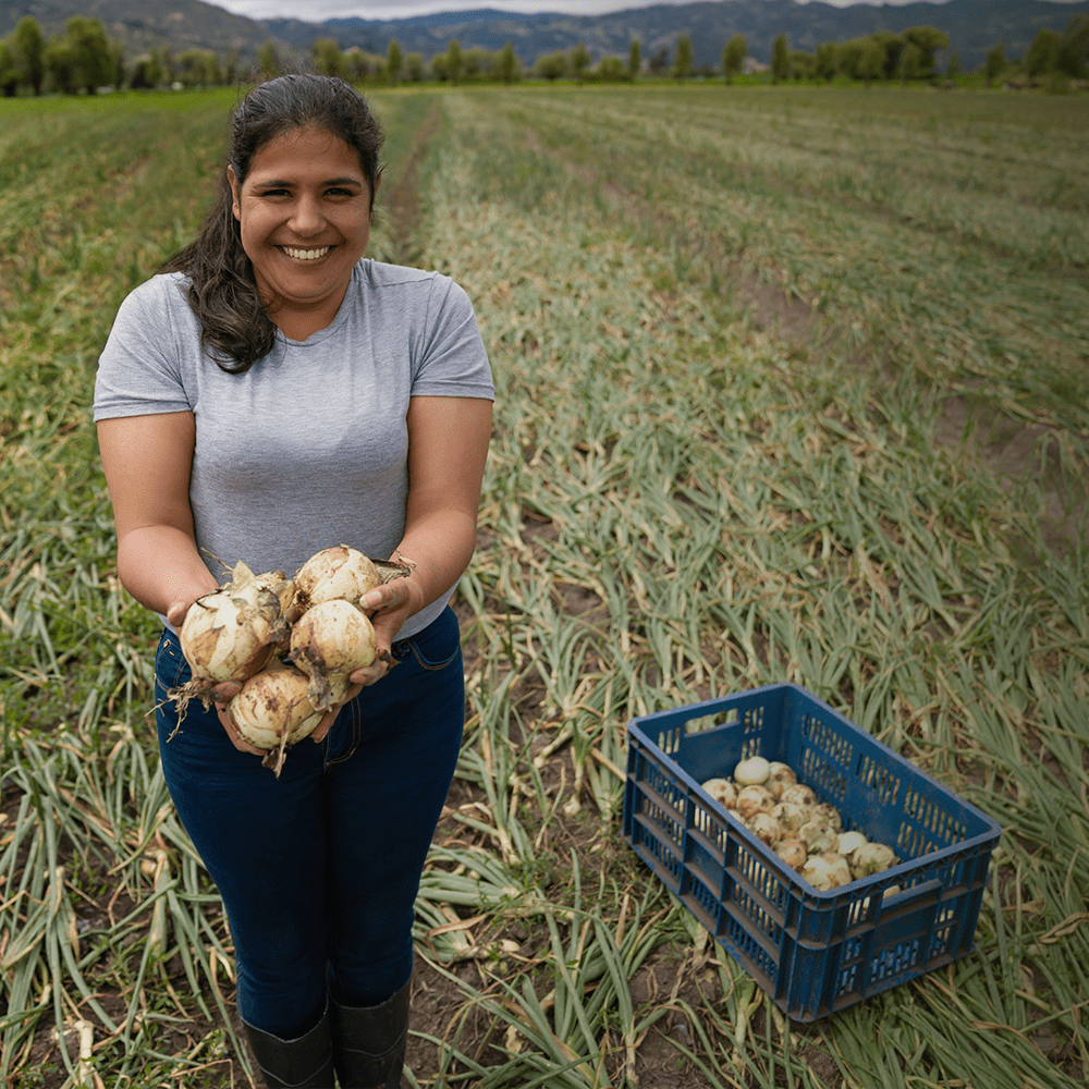 Woman in the field with onions she has harvested