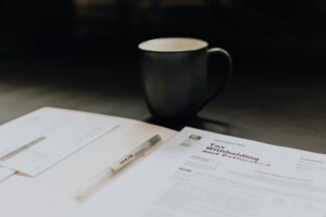 Coffee cup sitting next to documents to be signed