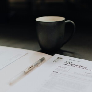 Coffee cup sitting next to documents to be signed